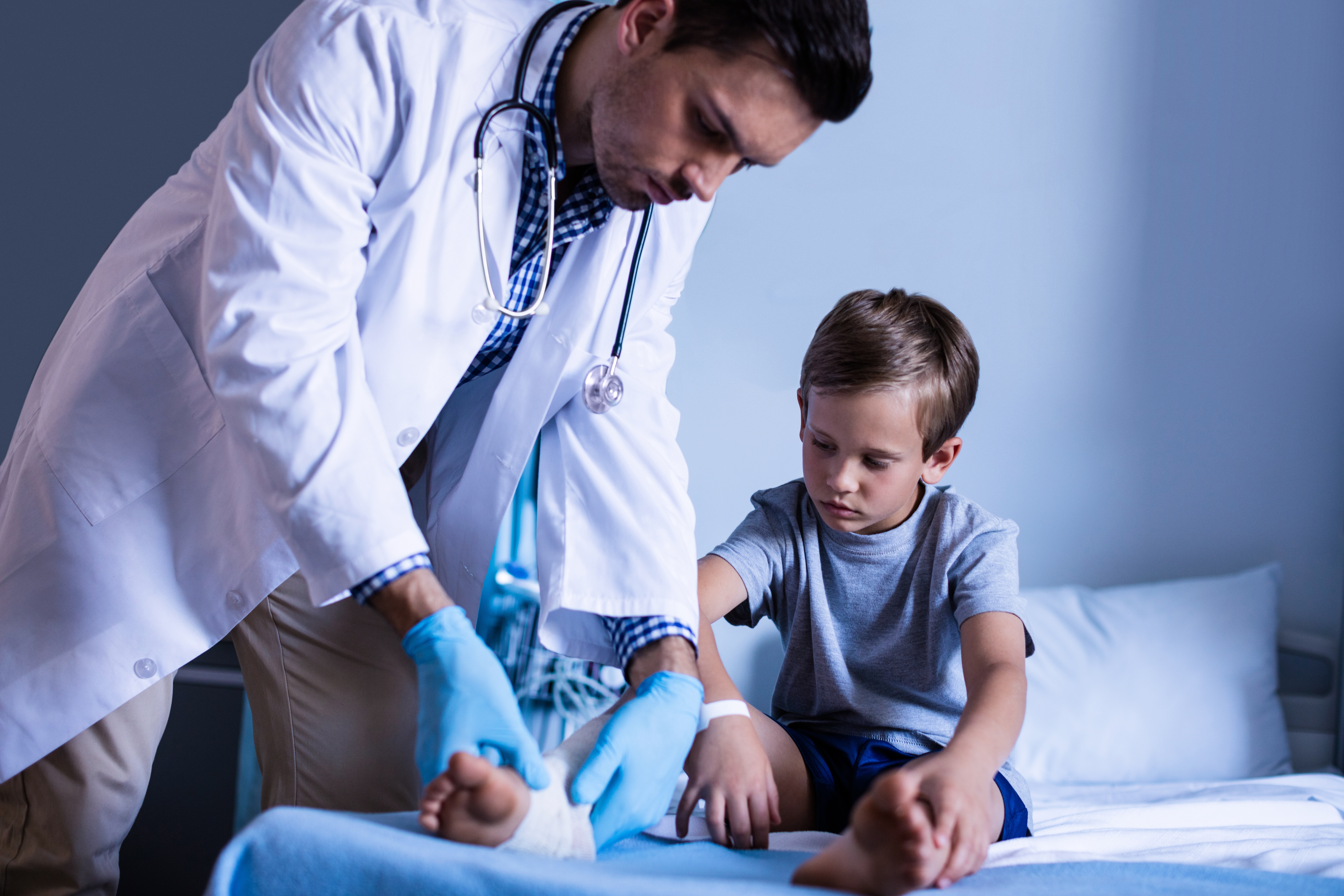 Врач осматривает мальчиков. Доктор осматривает ногу ребенка. Врач перевязывает ребенку. Хирург осматривает детей. Doctor examining Patient.